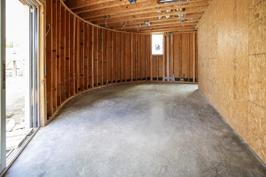 Cream-polished residential concrete slab with natural color and minimal aggregate exposure Light cream-polished concrete floor in a framed residential project