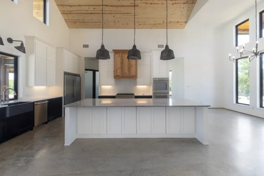 Cream-polished concrete floor in modern kitchen with natural surface variations and seamless finish