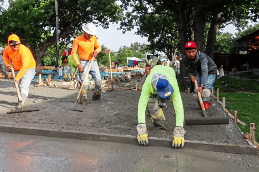 Troweling process to achieve flat slab for cream-finish concrete polishing Crew of concrete finishers using float pans and hand trowels to level freshly poured concrete