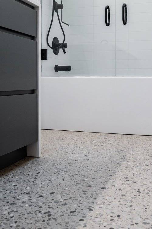 Low gloss "Class 1", Large Aggregate Exposed "Class D" Craftsman Concrete Floor. The aggregate has been chosen for its jagged shape and gray color. Notice how tightly the rock is incorporated into the floor, creating a terrazzo-style finish.